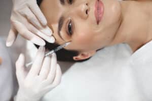Woman smiling as she gets facial injectables in Dallas, TX
