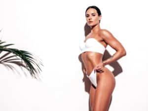 Woman in bikini after BBL and liposuction or tummy tuck in Dallas, TX
