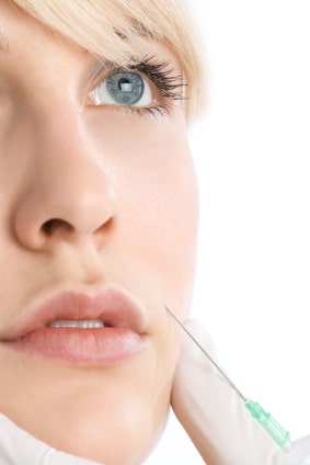 Close up of woman's face with syringe getting Restylane injections in Dallas, TX