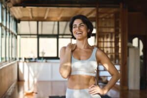 Woman smiling after working out to maintain liposuction results in Dallas, TX