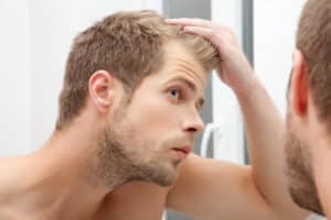 Man looking in the mirror after NeoGraft® in Dallas