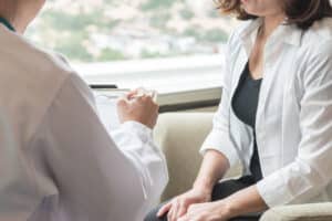 Woman talking to doctor about testing before plastic surgery in Dallas
