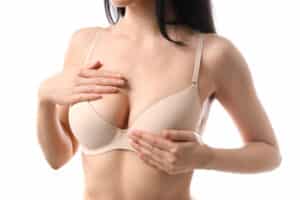 Cropped shot of a woman in a beige bra after breast implant revision